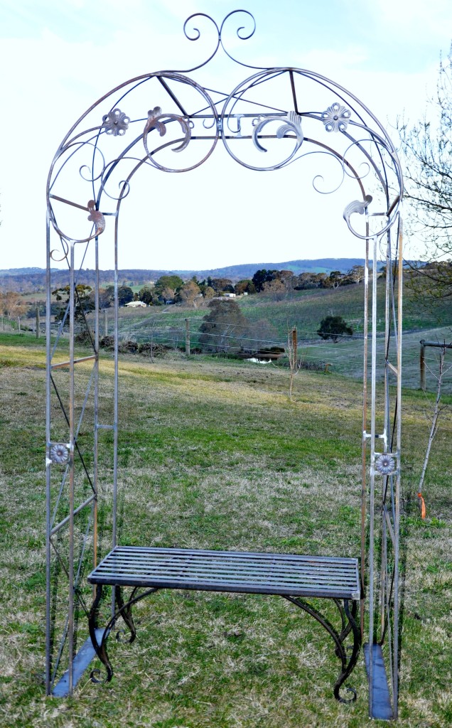 Wrought iron garden arch with bench